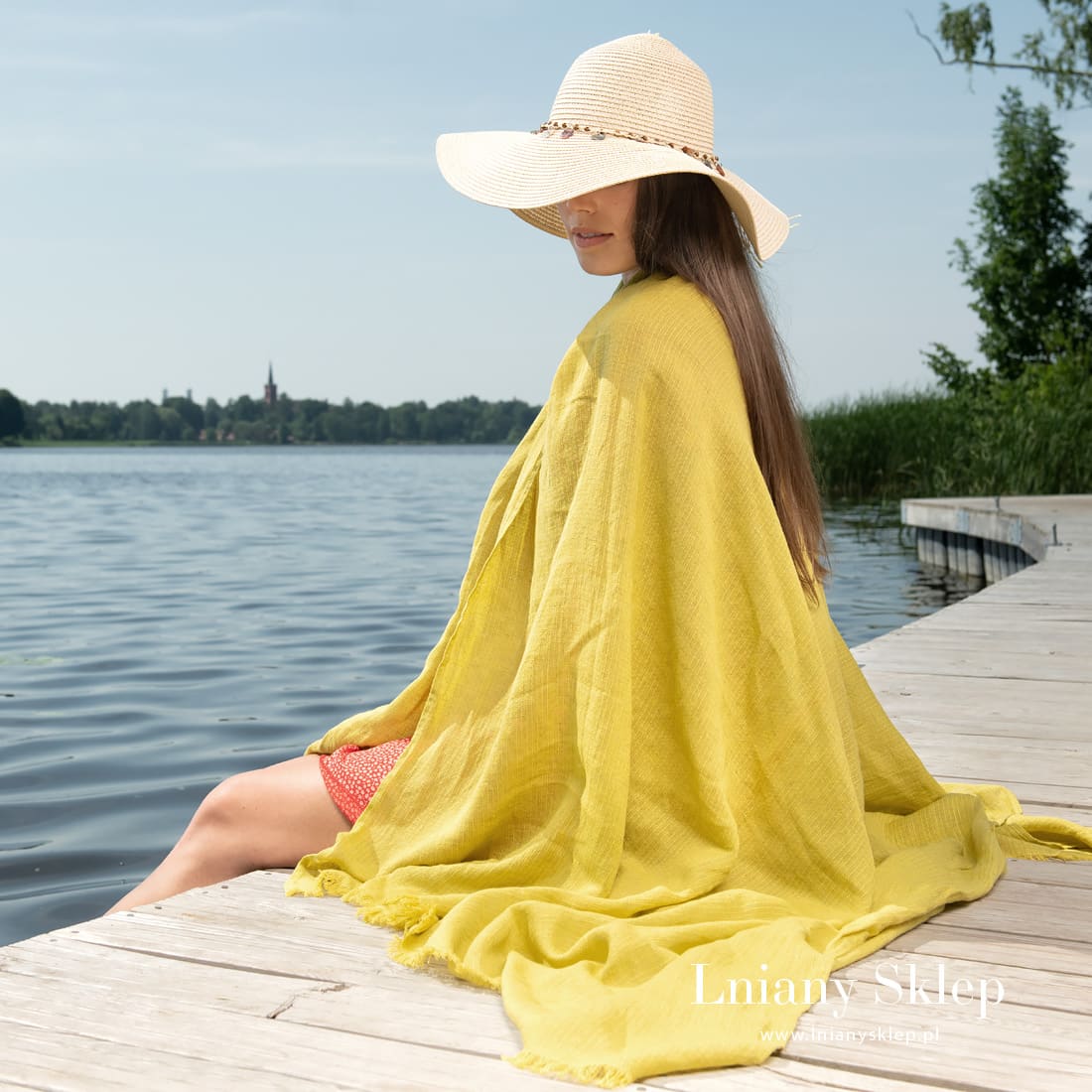 Żółty ręcznik plażowy wytkany w paski.